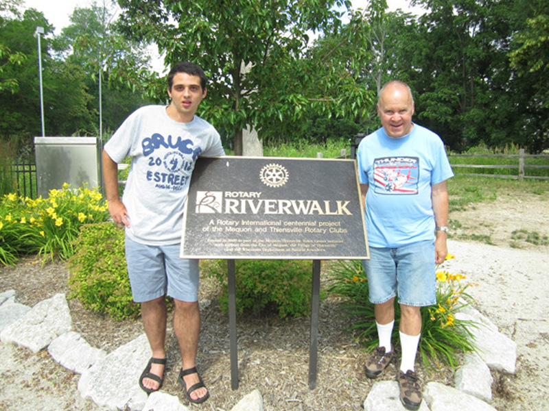 Guys Standing By Riverwalk Sign